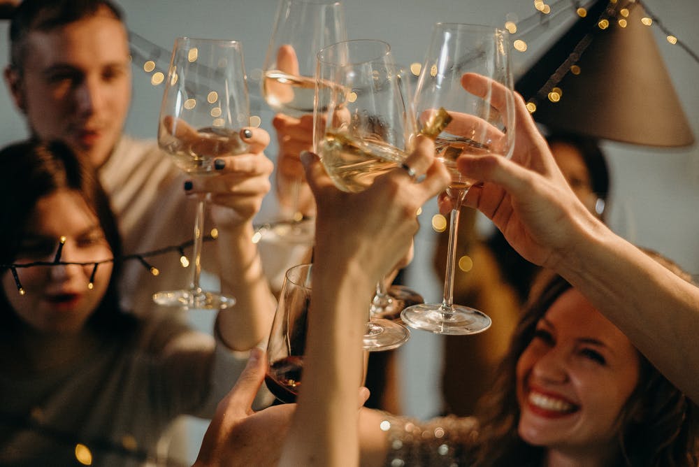 Lockdown Birthday Ideas. A group of people cheersing at a party.