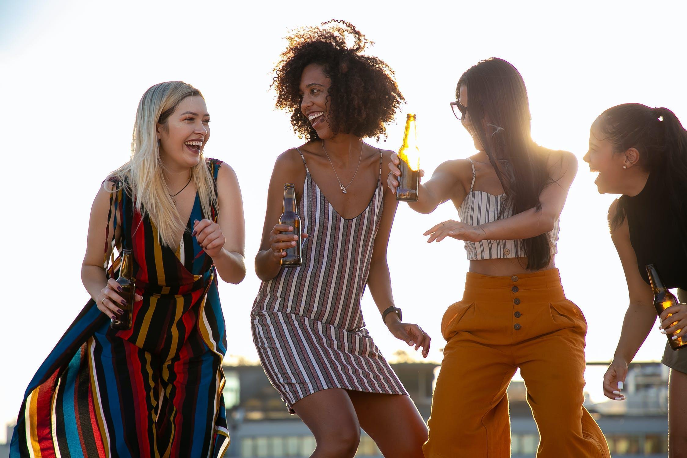 Lockdown Birthday Ideas. Four friends dancing outside.